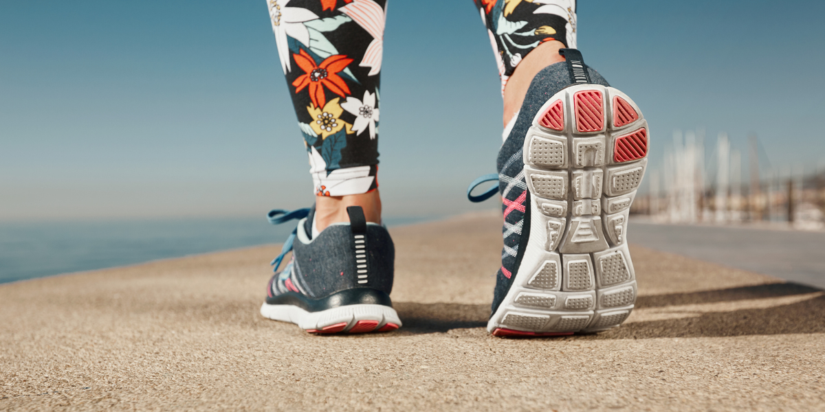 Runner woman feet running on road closeup on shoe. Female fitnes